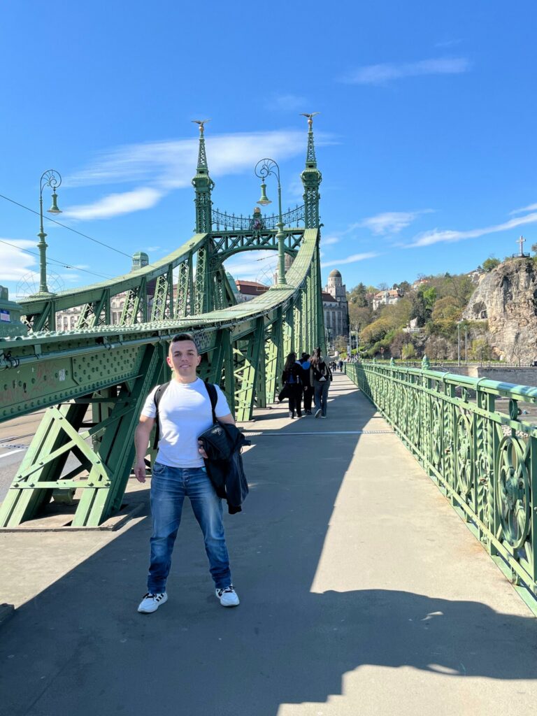 Hombre en el puente de la Libertad de Budapest, con la colina Gellért al fondo
